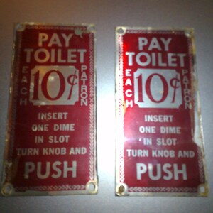 May include: Two vintage red metal signs with white lettering that read "Pay Toilet Each 10¢ Patron" and instructions to insert a dime, turn the knob, and push.