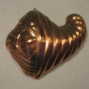 May include: A vintage copper turkey mold for baking. The mold is shaped like a turkey with a detailed head and neck.