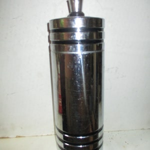 May include: A silver metal bottle with a black top and a black band around the middle. The bottle has a smooth, shiny surface.