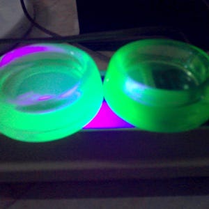 Hazel Atlas Uranium Glass Casters - set of 2 - 2.5&quot; diam. x 3/4&quot; deep - w logo - no chips or cracks