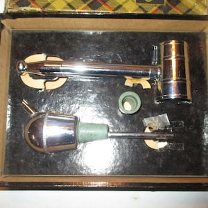 May include: A silver bottle opener and a silver bottle stopper in a black box with a green cork.