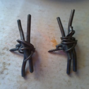 May include: Two metal hooks made from twisted wire with a screw at the end of each hook.