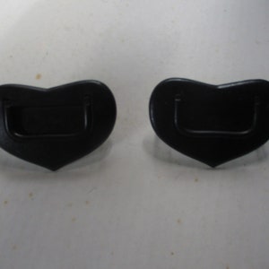 May include: Two black heart-shaped plastic handles with a rectangular cutout in the center.