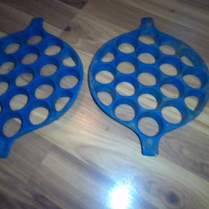 May include: Two blue silicone molds for making dumplings or other small treats. Each mold has 24 round depressions.