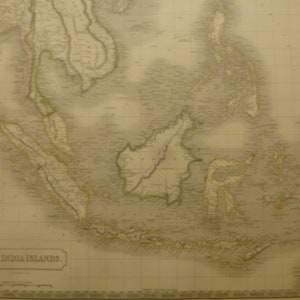 May include: An antique map of the East India Islands, featuring detailed geographical information. The map is printed on aged paper with a sepia tone, showcasing coastlines, islands, and geographical features. The title "East India Islands" is visible at the bottom.