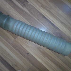 May include: A gray, flexible, corrugated plastic tube with a rounded end.