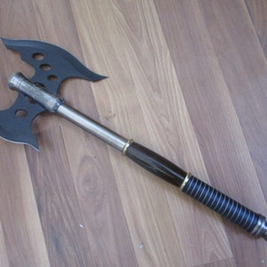 May include: A black double-headed axe with a silver handle and a black and gold grip.