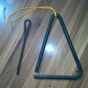 May include: A black metal triangle with a yellow string attached to it. A black metal striker is also included.