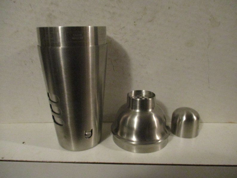 K&ouml;nnte beinhalten: Cocktail-Shaker-Set aus Edelstahl, bestehend aus einem gro&szlig;en Shaker, einem Sieb und einem Deckel. Der Shaker hat ein konisches Design mit drei Aussparungen. Das Set dient zum Mixen von Getr&auml;nken.