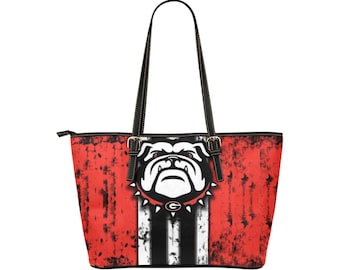 May include: A red and black tote bag with a distressed look. The bag features a white bulldog mascot with a black collar and a gold 'G' on the collar. The bag has black straps and a zipper closure.