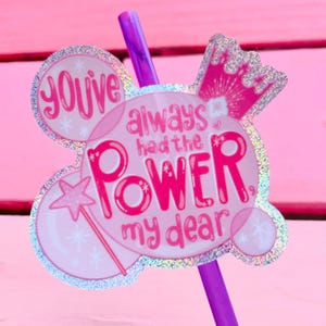 May include: Pink and white glitter sticker with a crown and the text "You've always had the power, my dear".