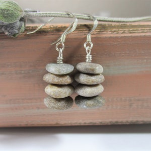 May include: A pair of silver earrings with a stack of four small, gray and brown stones on each earring.