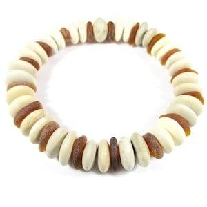 May include: A handmade bracelet featuring a circular design of alternating white and brown, flat, disc-shaped beads. The bracelet is made of natural materials and is displayed on a white background. The beads have a smooth, polished appearance.