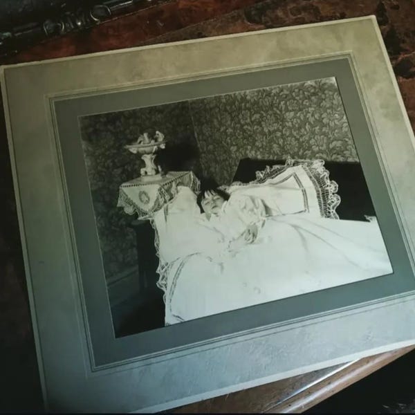 Large matted original Victorian post-mortem photo of a young child posed as if sleeping.