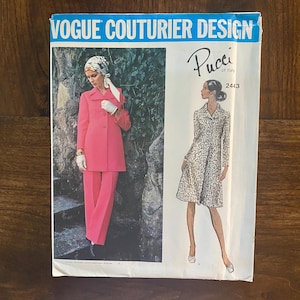 May include: Vintage Vogue Couturier Design sewing pattern featuring a pink trouser suit and a white dress with a black print. The pattern is by Pucci of Italy and the pattern number is 2443.