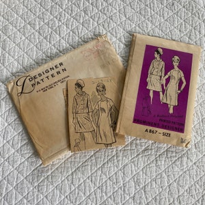 May include: Vintage sewing pattern envelope with a pink and white illustration of a dress and jacket. The pattern is for size 14 and is called "A Radiant Original Printed Pattern Prominent Designer A 867".