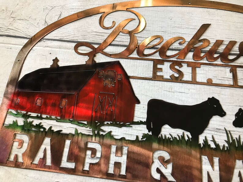May include: Metal sign with a red barn, two black cows, and the text "Beckwith Est. 1987 Ralph & Nancy". The sign has a rustic, weathered look.