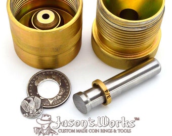 May include: A set of two gold-colored metal coin ring making tools with a silver metal rod and a coin ring. The tools are made of metal and have a textured surface. The coin ring is labeled "3/4".