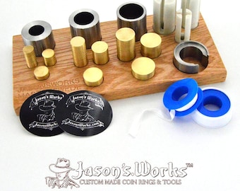 May include: A set of coin ring making tools on a wooden base. The set includes various sized metal mandrels, a metal ring former, and two rolls of blue and white tape. The tools are labeled "Jason's Works".