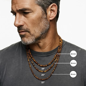 May include: Three beaded necklaces with varying bead sizes (4mm, 6mm, and 8mm) and lengths (18", 20", and 22"). The necklaces are a warm brown color and are displayed on a person wearing a gray t-shirt.
