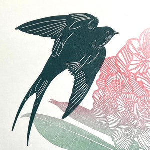 May include: A black silhouette of a swallow bird with its wings spread, flying over a pink and white floral design.