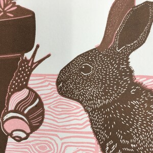 Linocut print of a baby rabbit looking at a snail image 2