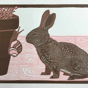 Linocut print of a baby rabbit looking at a snail