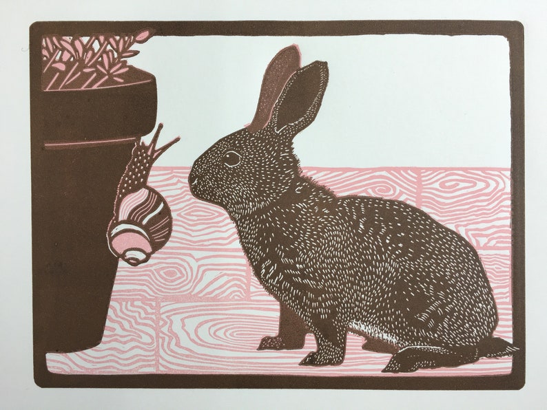 Linocut print of a baby rabbit looking at a snail image 1