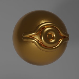 Pode incluir: Uma esfera dourada com um design de olho em relevo. O olho é contornado por uma faixa de ouro mais grossa.
