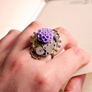 May include: A purple flower ring with a steampunk design featuring gears and metal accents.