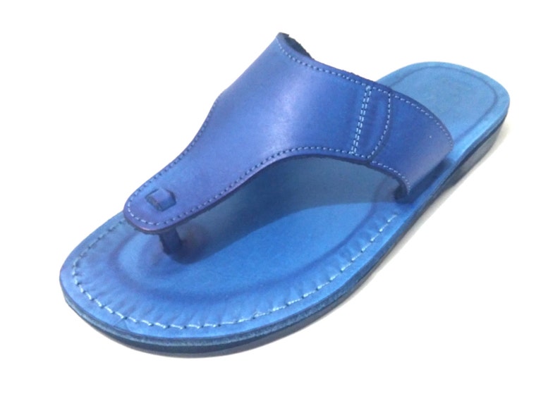 Peut inclure: Une paire de sandales en cuir bleu avec un design simple. Les sandales ont une seule sangle qui passe entre les orteils et un bord cousu.