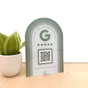 May include: A green and white acrylic sign with a Google review QR code, five stars, and the text "Thank you for your review". The sign also includes the text "Your Business Name".