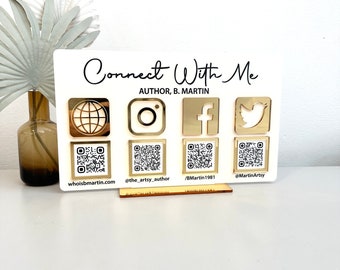 May include: White sign with the text "Connect With Me" and "Author, B. Martin".  The sign has four gold icons: a globe, Instagram, Facebook, and Twitter.  Each icon has a QR code underneath it with a corresponding website or social media handle.