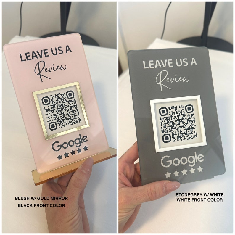 K&ouml;nnte beinhalten: Zwei Acryl-Bewertungsschilder. Eines ist blassrosa mit goldenen Spiegelakzenten, das andere steingrau mit wei&szlig;en Akzenten. Beide haben einen QR-Code, das Google-Logo und den Text "LEAVE US A Review".
