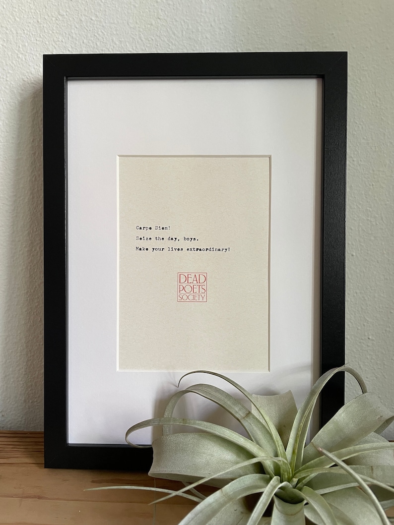 May include: A framed print with the text "Carpe Diem! Seize the day, boys. Make your lives extraordinary!" and a red logo that says "Dead Poets Society".