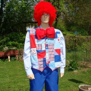May include: A person wearing a red wig, a blue and white patchwork vest with a red bow tie, and blue pants with patchwork trim.