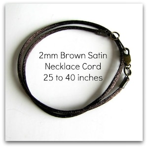May include: A brown satin cord necklace, 2 mm wide, with a lobster clasp. The cord is available in lengths from 25 to 40 inches.