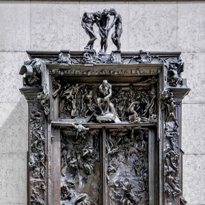 May include: A large, ornate bronze sculpture depicting a scene of chaos and struggle. The sculpture is divided into two sections, each with a different scene. The top section features three figures, while the bottom section features a more complex scene with many figures. The sculpture is a classic example of the artist's work.