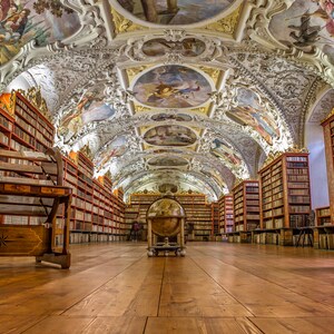 May include: A large, ornate library with high ceilings and rows of bookshelves filled with books. The library has a wooden floor and a globe in the center of the room.