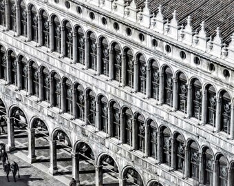 May include: A black and white photo of a building with many arches and columns. The building is made of stone and has a lot of detail. The photo is taken from a high angle, looking down at the building.