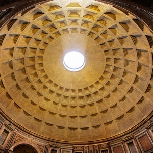 May include: A close-up view of the interior of a dome with a circular opening in the center. The dome is made of a light brown material and has a pattern of squares and rectangles. The opening in the center is surrounded by a ring of light brown material.