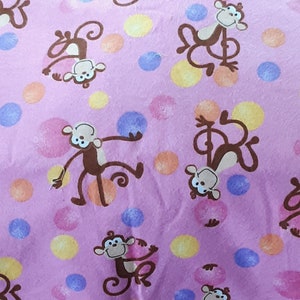 Può includere: Tessuto rosa con un motivo ripetitivo di scimmie marroni e pois colorati.