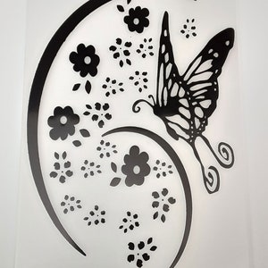 May include: Black and white silhouette of a butterfly with wings spread, flying above a swirl of flowers. The design is on a clear plastic sheet.