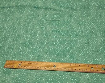 May include: A piece of teal fabric with a white polka dot pattern. A wooden ruler is placed across the fabric, measuring up to 30 inches. The fabric has a soft, textured appearance.