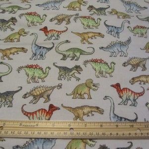 White With Multicolored Dinosaurs Flannel Fabric by the Yard