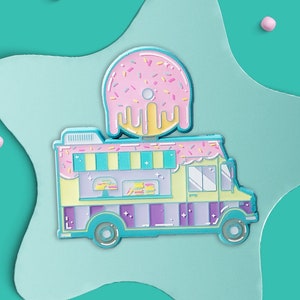 May include: A pastel pink and blue enamel pin of a food truck with a pink and white doughnut on top. The truck has a yellow body, purple and white stripes, and a white roof with a blue awning. The doughnut has pink frosting and sprinkles.