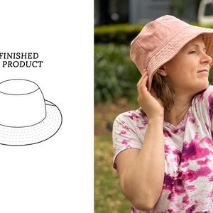 May include: A pink bucket hat with a wide brim. The hat is made of a soft, lightweight fabric and has a simple, classic design.