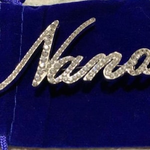 Broche de solapa con diamantes de imitación de plata transparente de Nana de 3" con guión NUEVO con bolsa de terciopelo