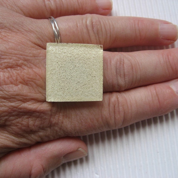 BAGUE carrée ou ronde ajustable unisexe, sur fond beige en résine format 25mm