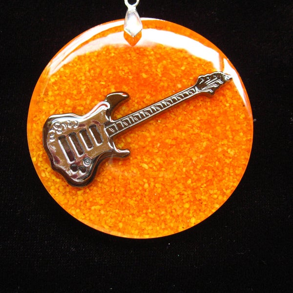 PROMOTION Très grand pendentif unisexe Guitare noire sur fond orange en résine monté sur un cordon noir diamètre 50mm